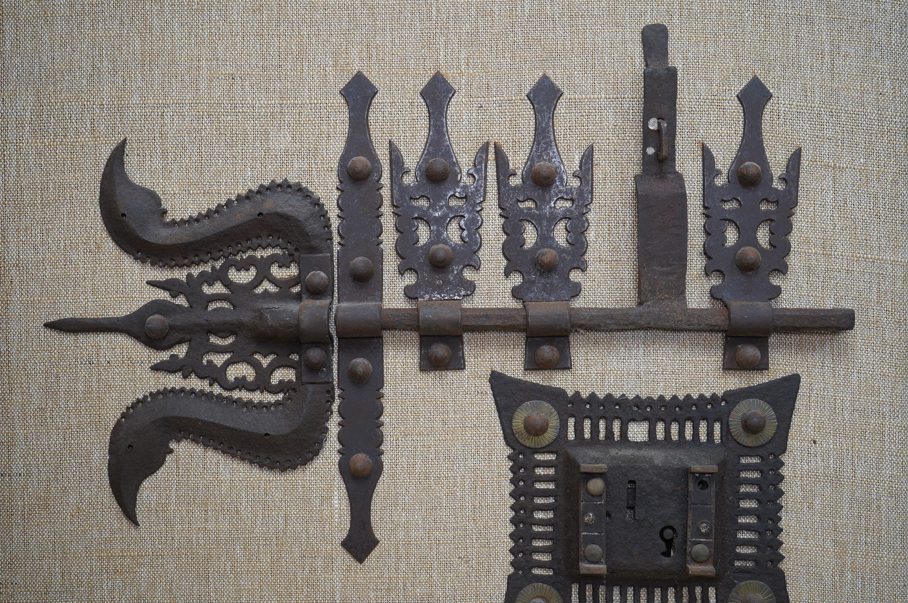 A 17th/18th century continental iron door furniture display, mounted on a board, no key, 65cm high. Condition - good